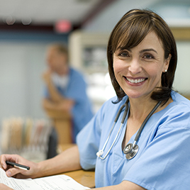 physician-smiling-and-looking-at-camera-with-paperwork-in-hand