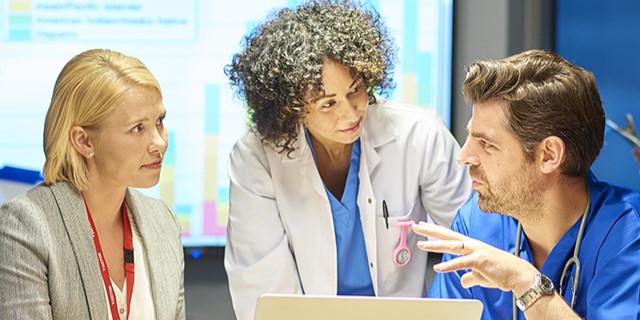 doctors and staff around a computer